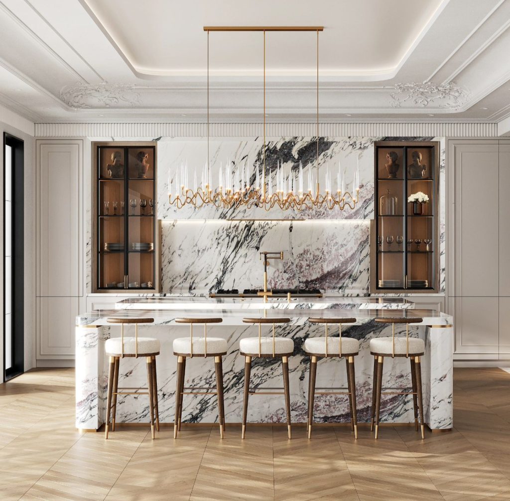 Modern luxury kitchen with a large marble island, white cushioned bar stools, and ornate pendant lighting. The cabinetry features glass doors, and the floor is made of light-colored wood.